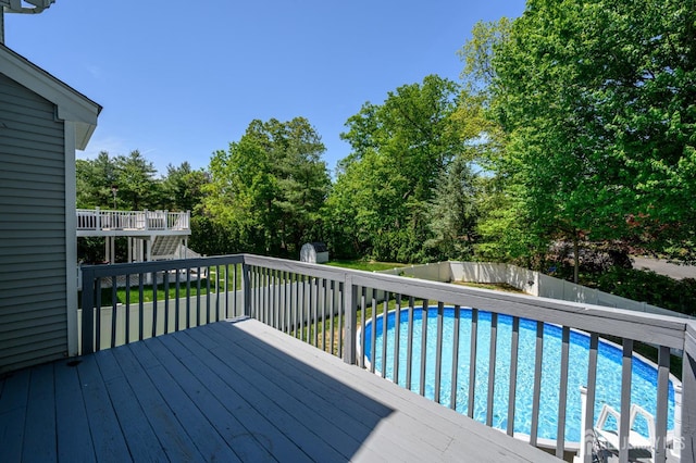 wooden terrace with a fenced backyard, stairway, and view of wooded area