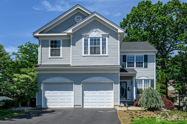 view of front facade with asphalt driveway and an attached garage