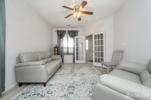living room featuring french doors, ceiling fan, wood finished floors, and baseboards