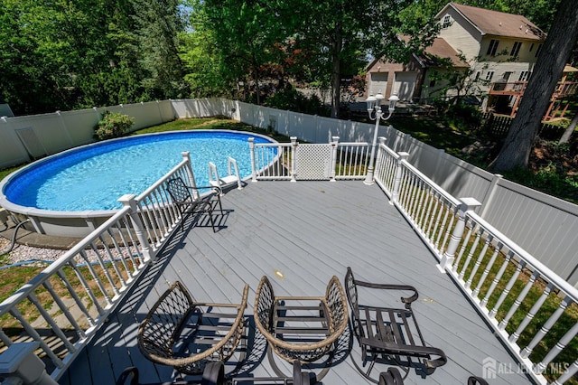view of pool with a fenced backyard and a wooden deck