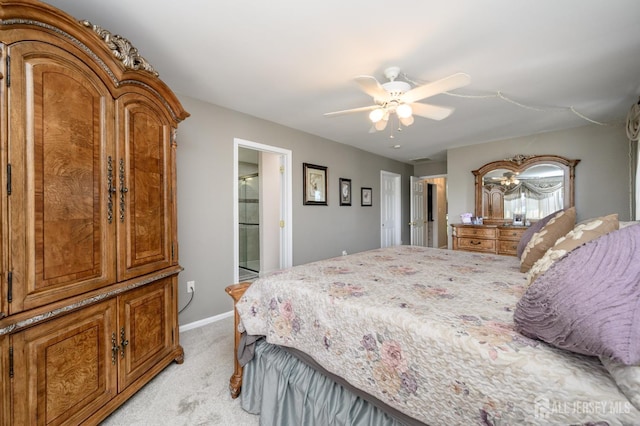 bedroom with light colored carpet, baseboards, ceiling fan, and connected bathroom