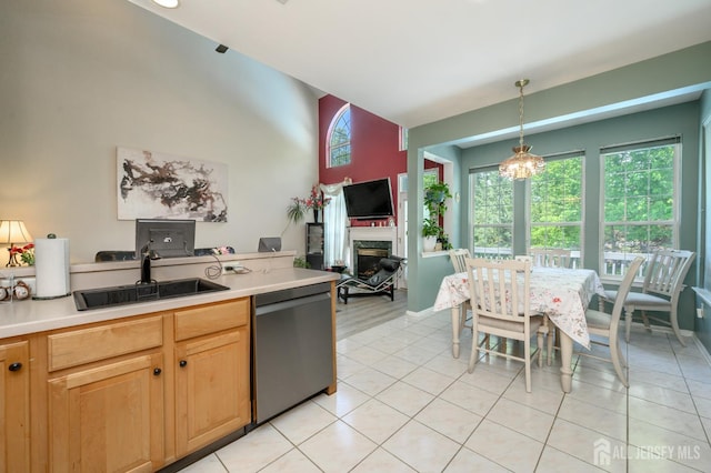 kitchen featuring dishwasher, a sink, healthy amount of natural light, light countertops, and high vaulted ceiling