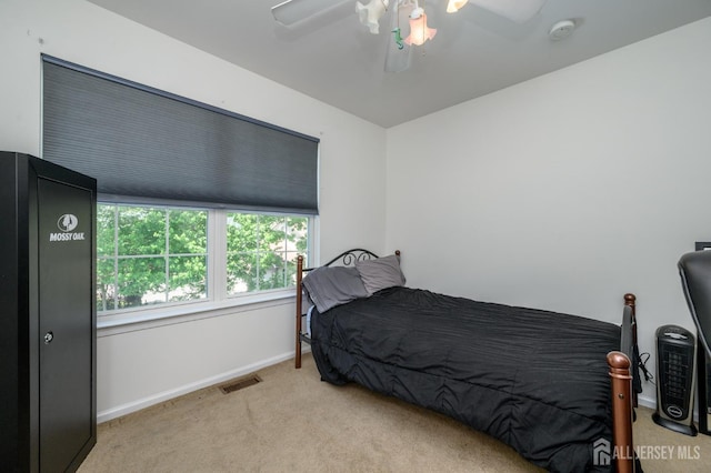 bedroom with light colored carpet, baseboards, and ceiling fan