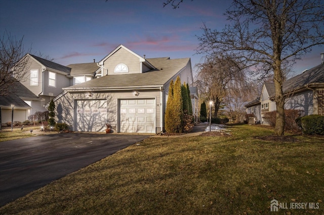 property exterior at dusk featuring a garage and a lawn