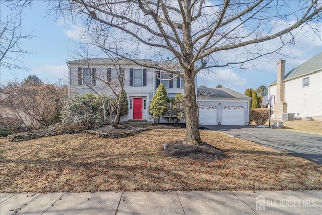 view of front of property featuring entry steps, an attached garage, cooling unit, and driveway