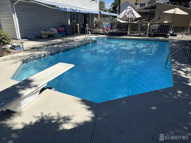 view of pool featuring a fenced in pool, a patio area, and a diving board