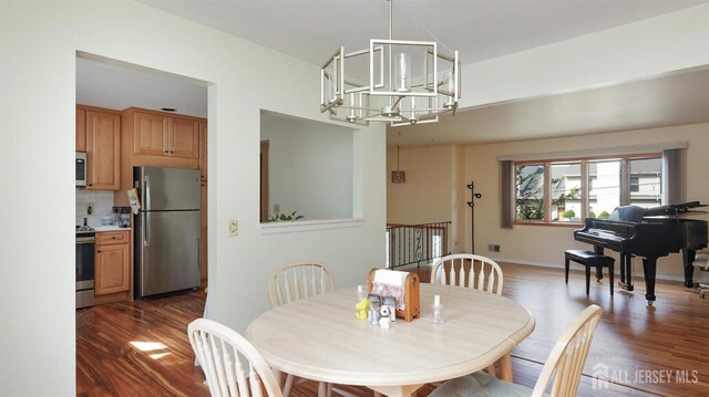 dining area with a notable chandelier and dark hardwood / wood-style floors