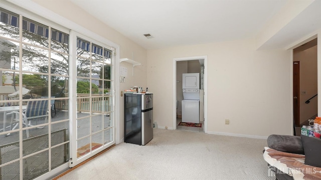 living area featuring stacked washer and clothes dryer and carpet floors