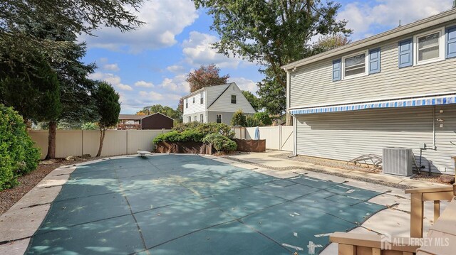 view of swimming pool with a patio area, central AC, and a fenced backyard