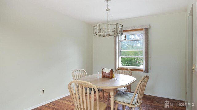 dining area with a chandelier, baseboards, and wood finished floors