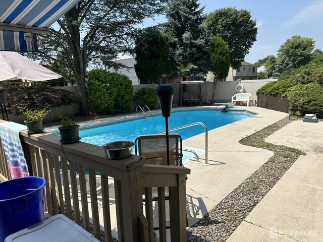 view of swimming pool with a diving board, a patio, a fenced backyard, and a fenced in pool