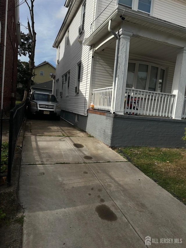 view of home's exterior featuring a porch and driveway