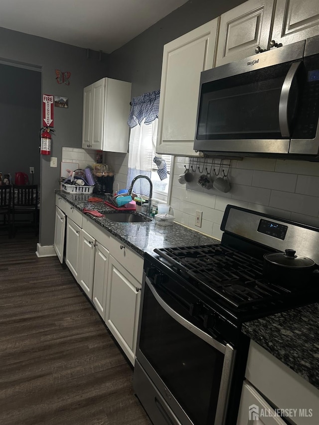 262 Hale St, New Brunswick, NJ 08901 - kitchen with dark wood finished floors, decorative backsplash, stainless steel appliances, white cabinets, and a sink