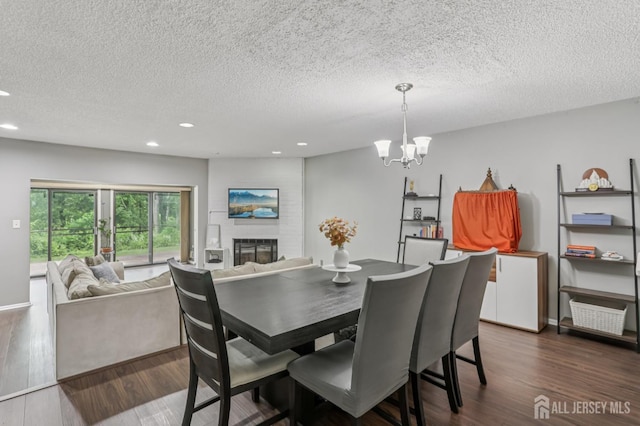 91 Pear Tree Ln, Franklin, NJ 08823 - dining area with a textured ceiling, recessed lighting, a chandelier, dark wood-style floors, and a large fireplace