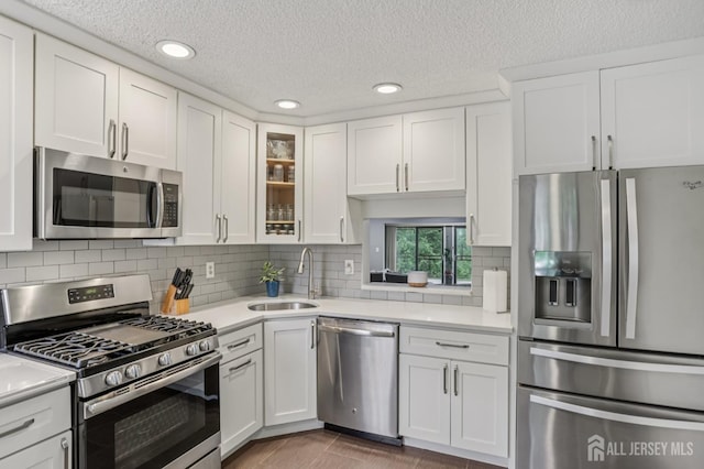 91 Pear Tree Ln, Franklin, NJ 08823 - kitchen with stainless steel appliances, light countertops, white cabinetry, recessed lighting, and a textured ceiling