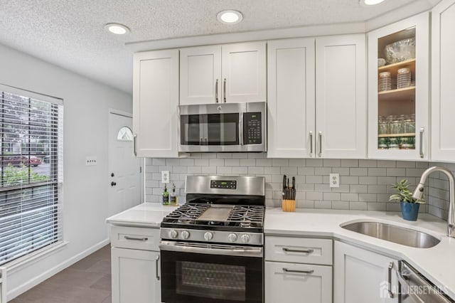 91 Pear Tree Ln, Franklin, NJ 08823 - kitchen featuring appliances with stainless steel finishes, light countertops, backsplash, white cabinetry, and a textured ceiling