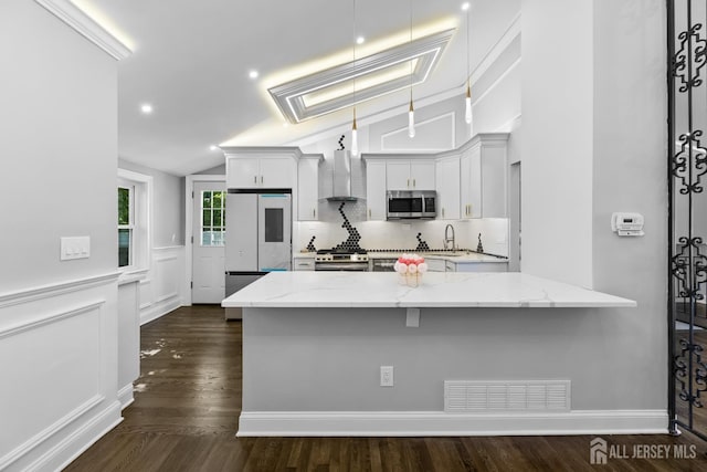4 Arden Rd, Old Bridge, NJ 08857 - kitchen with appliances with stainless steel finishes, wall chimney exhaust hood, vaulted ceiling, decorative backsplash, and light stone countertops