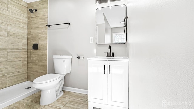 full bathroom with a shower stall, toilet, vanity, and baseboards