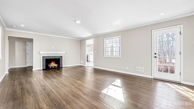 unfurnished living room with visible vents, baseboards, and ornamental molding