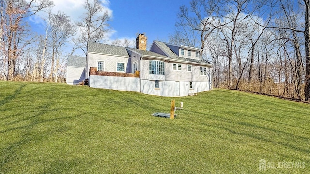 exterior space featuring a chimney and a lawn