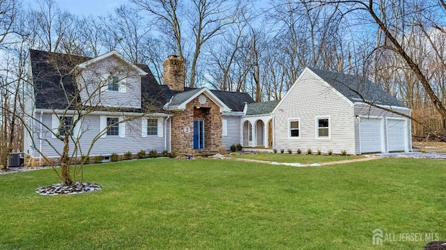 view of front of house with a chimney, central AC unit, a front lawn, an attached garage, and driveway
