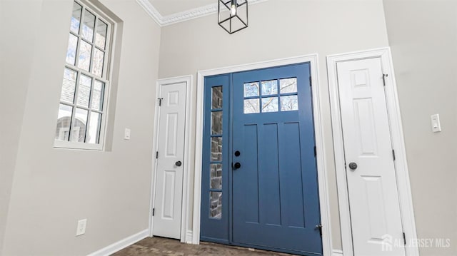 entryway with baseboards and crown molding