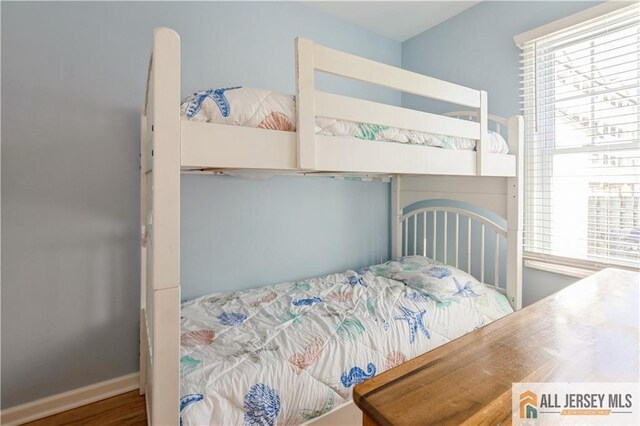 bedroom with wood-type flooring and multiple windows