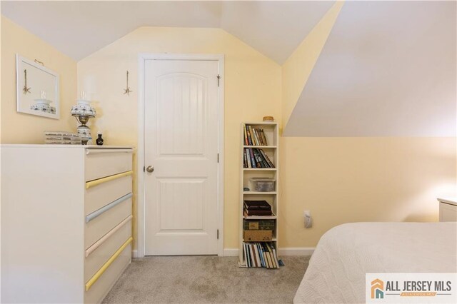 bedroom featuring light colored carpet and lofted ceiling