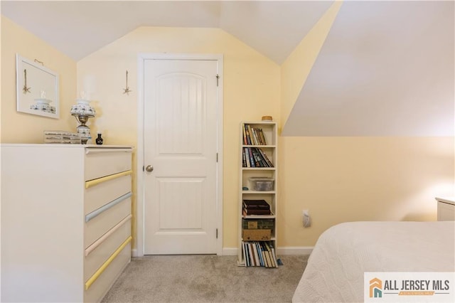 bedroom featuring lofted ceiling and light carpet