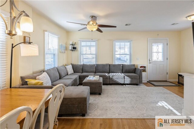 living room featuring ceiling fan and hardwood / wood-style floors