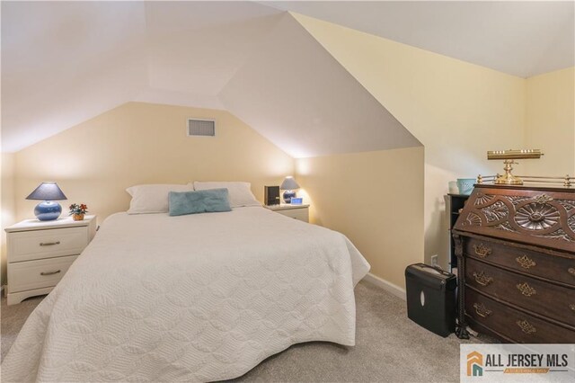 bedroom with light colored carpet and lofted ceiling