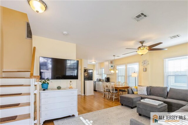 living room with ceiling fan and light wood-type flooring