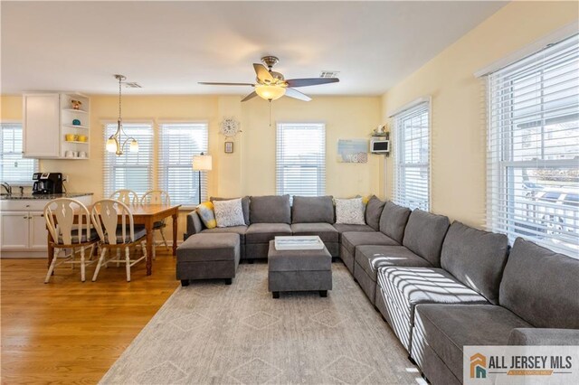 living room with ceiling fan and light wood-type flooring