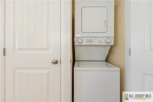 clothes washing area featuring stacked washing maching and dryer