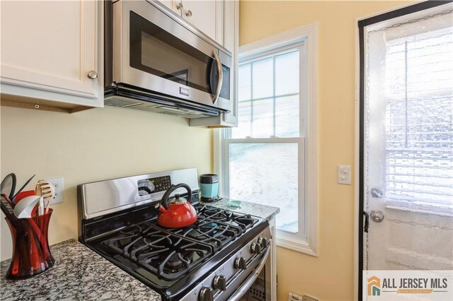 kitchen with white cabinets, appliances with stainless steel finishes, and plenty of natural light