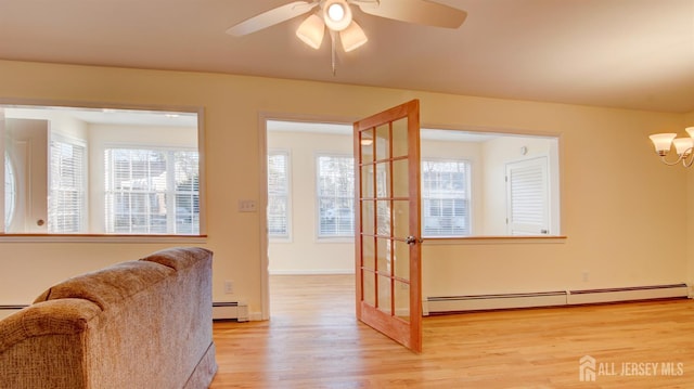 3 Cypress St Unit C, Toms River, NJ 08757 - living area featuring a baseboard heating unit, light wood finished floors, a ceiling fan, and a chandelier