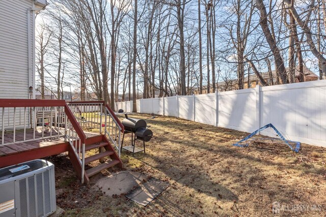 view of yard with a deck and central air condition unit