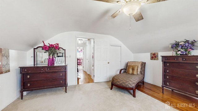 living area featuring vaulted ceiling, light colored carpet, and ceiling fan