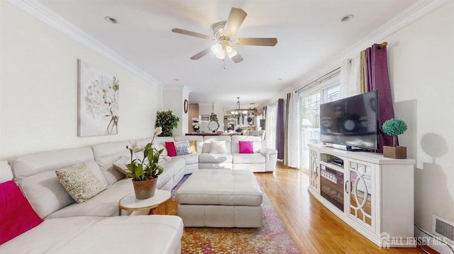 living room with ceiling fan with notable chandelier, light wood-type flooring, and crown molding