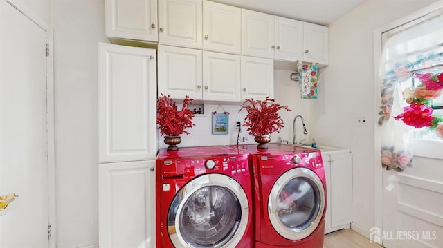 washroom featuring cabinets, washing machine and dryer, and sink