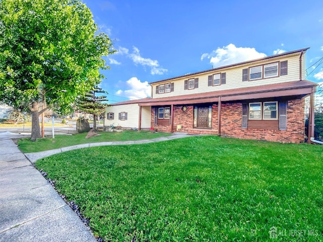 view of front of home featuring a front lawn and brick siding