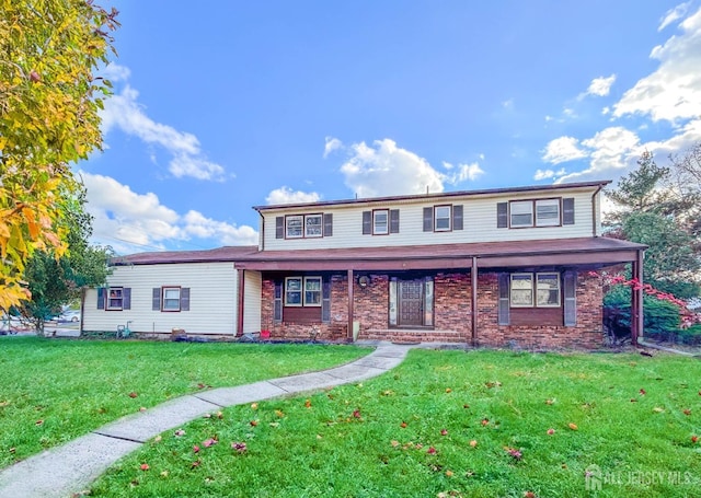 view of front of home with a front yard and brick siding