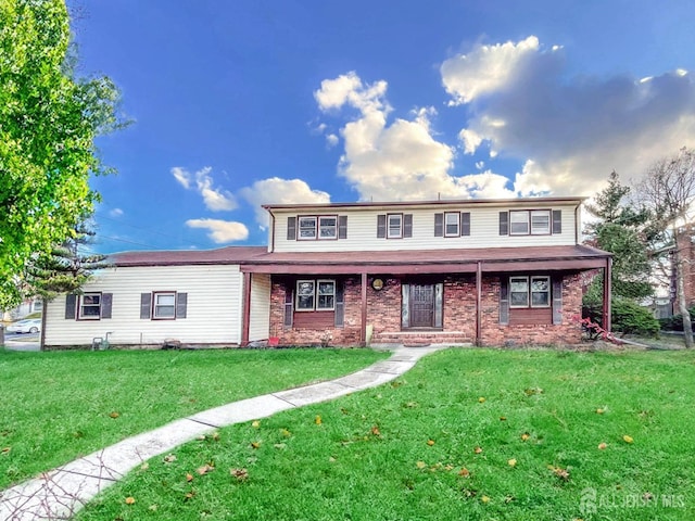 traditional home featuring a front lawn and brick siding