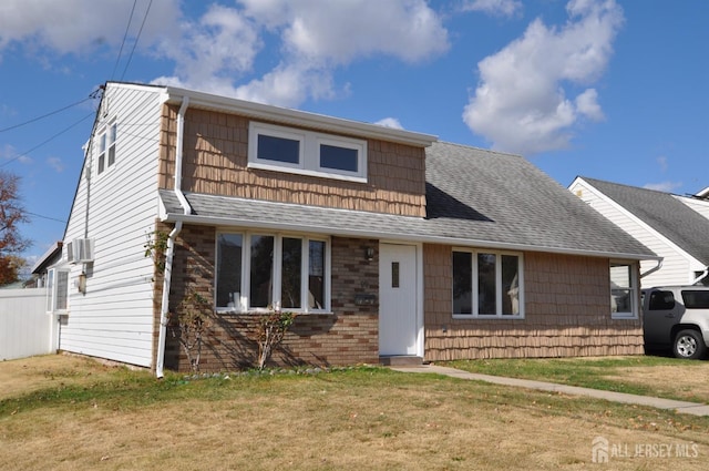 view of front of home featuring a front yard and a wall mounted AC