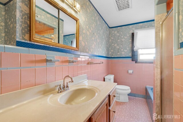 full bathroom with separate shower and tub, vanity, tile walls, and toilet