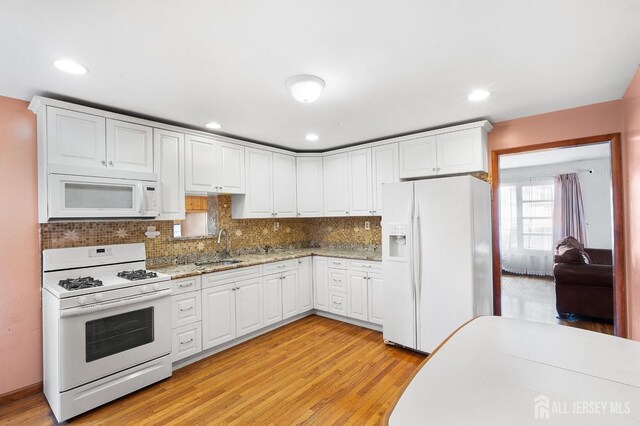 kitchen featuring light hardwood / wood-style flooring, white cabinets, and white appliances