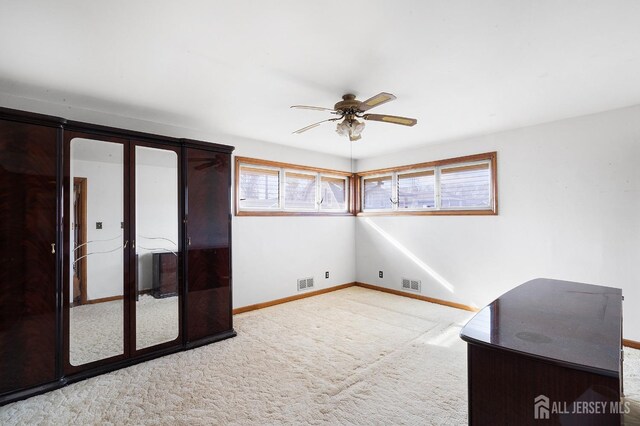 interior space featuring ceiling fan and light colored carpet