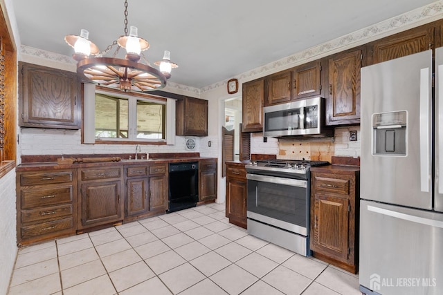 107 Athens Ave, Old Bridge, NJ 08879 - kitchen featuring appliances with stainless steel finishes, a chandelier, dark countertops, light tile patterned flooring, and backsplash