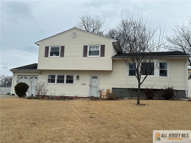 split level home with an attached garage and a front yard