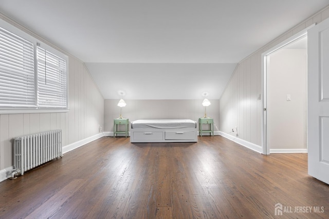 unfurnished bedroom featuring radiator, dark hardwood / wood-style floors, and lofted ceiling